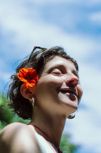 Low angle view of smiling woman against sky