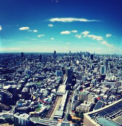 High angle view of buildings in city against blue sky