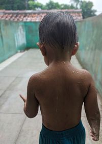 Rear view of shirtless boy in swimming pool