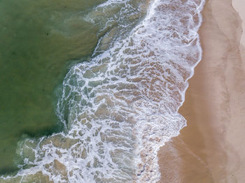 High angle view of waves rushing towards shore