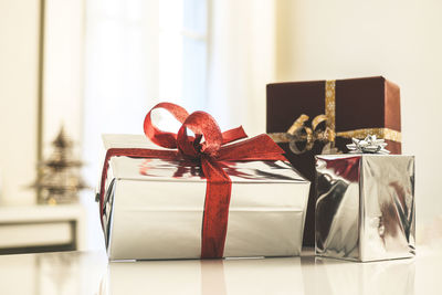 Gift boxes near christmas tree inside home. box with holiday ribbon with bows. festive atmosphere