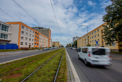 Railroad tracks amidst buildings in city against sky