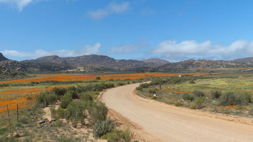 Road by landscape against sky