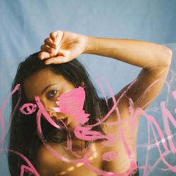 Portrait of woman standing against glass