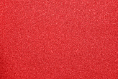 Red glitter textured background with copy space