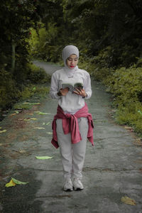 Full length of woman standing on footpath