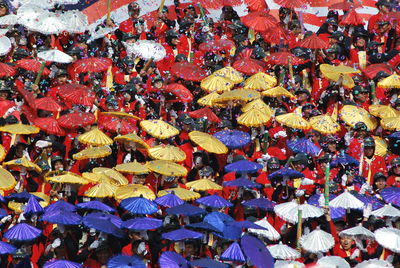 Confetti falling on people with colorful umbrellas during celebration
