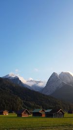 Scenic view of landscape and mountains against blue sky