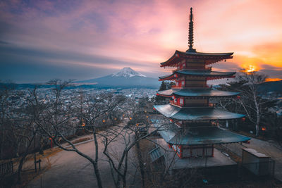 Pagoda against cloudy orange sky during sunset