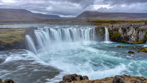 Scenic view of waterfall against sky