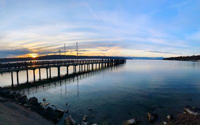 Pier over sea against sky during sunset