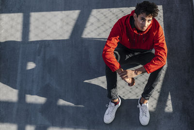 Full length of young man sitting in city