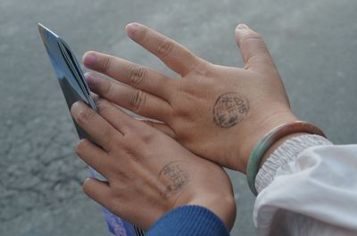 Cropped hands of people with stamps against street