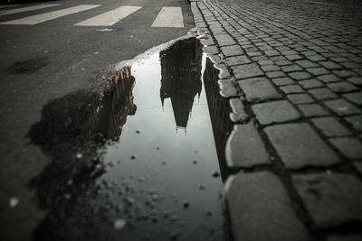 Reflection of building in puddle on road