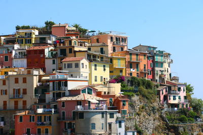 Buildings in city against clear blue sky