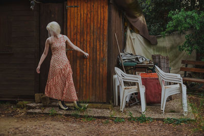 Young woman standing against wooden door