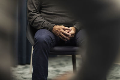 Mid section of man sitting during meeting