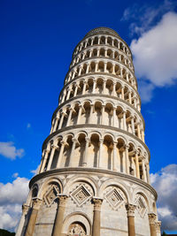 Low angle view of the leaning tower of pisa against blue sky