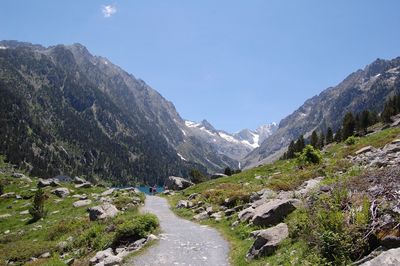Narrow footpath towards lake in the mountains