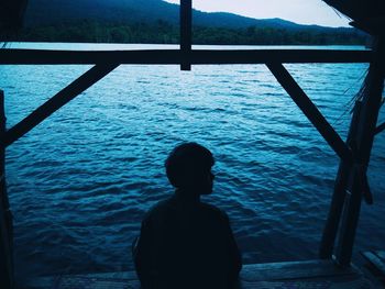 Rear view of silhouette man looking at sea