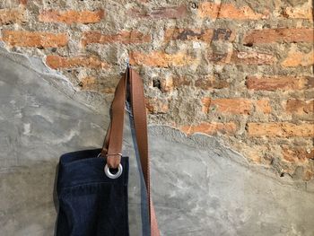 Close-up of apron clothes hanging on old brick wall