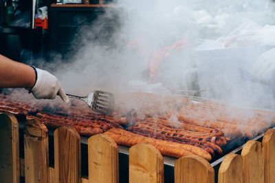 Close-up of man cooking on barbecue grill