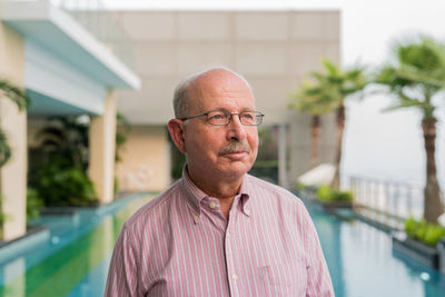 Portrait of man standing against building