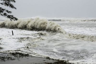 Close-up of wave on beach against sky