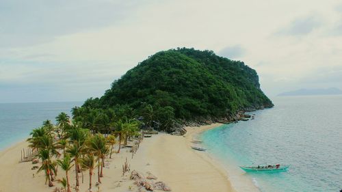 Scenic view of island against cloudy sky