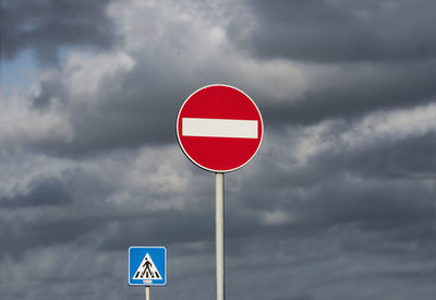 Road signs against cloudy sky