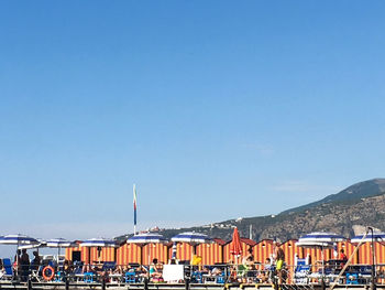 Boats in sea against clear blue sky