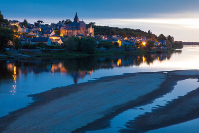 Reflection of illuminated buildings in lake at dusk