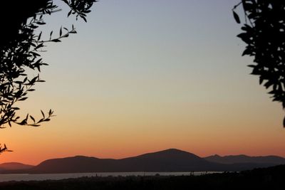 Scenic view of silhouette mountains against clear sky during sunset