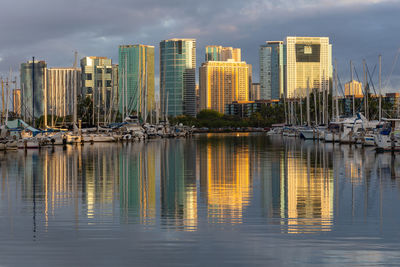 Honolulu skyline reflected in the marina harbor at sunrise