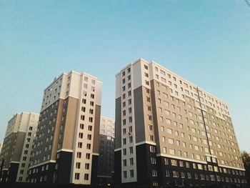 Low angle view of modern buildings against clear blue sky