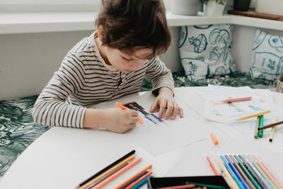 The boy draws with felt-tip pens. high quality photo