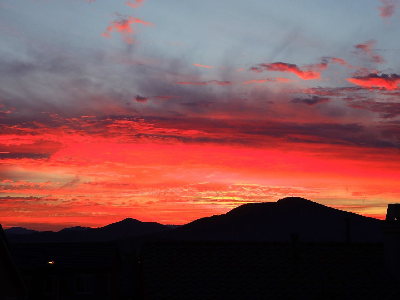 SILHOUETTE MOUNTAINS AGAINST DRAMATIC SKY