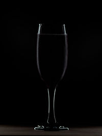 Wineglass on table against black background