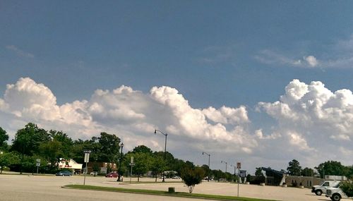 Cars on road against cloudy sky