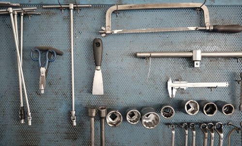 Hand tools hanging on metal in workshop