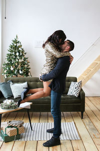 A man and a woman in love are preparing together and celebrating new year and christmas at home