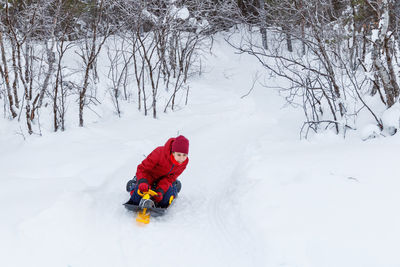 Girl sledding on a snow track, family vacation