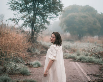 Woman in misty woods looking back. 