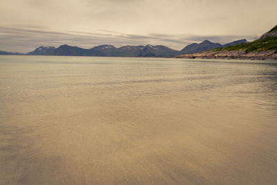 Scenic view of sea and mountains against sky