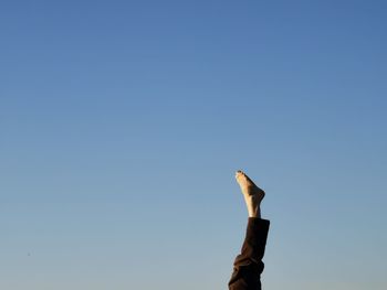 Low angle view of hand against clear blue sky