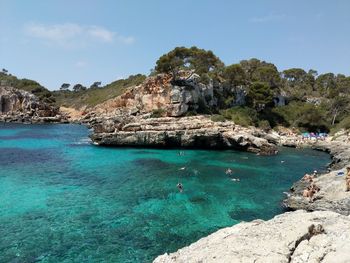 Scenic view of rocks on sea against sky