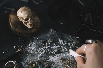 Cropped hand of woman writing on rock