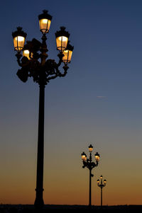 Low angle view of illuminated street light against clear sky