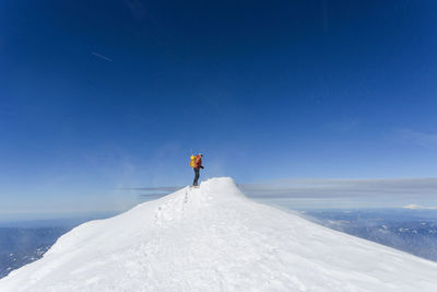 A man climbs to the summit of mt. hood in oregon.