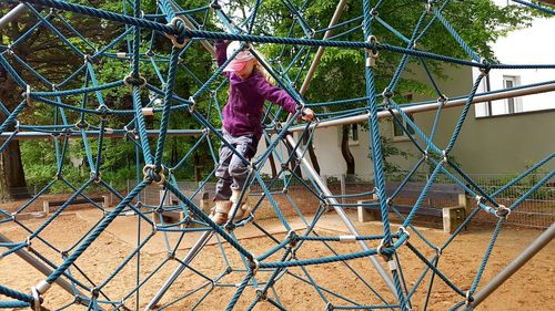 Full length of girl playing at jungle gym in playground